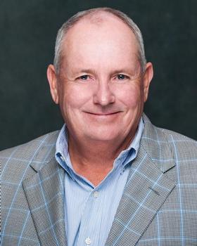 Smiling man in a checkered blazer