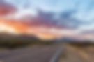 road-through-dramatic-sunset-and-sky-over-desert-landscape-picture-id950173000.jpg