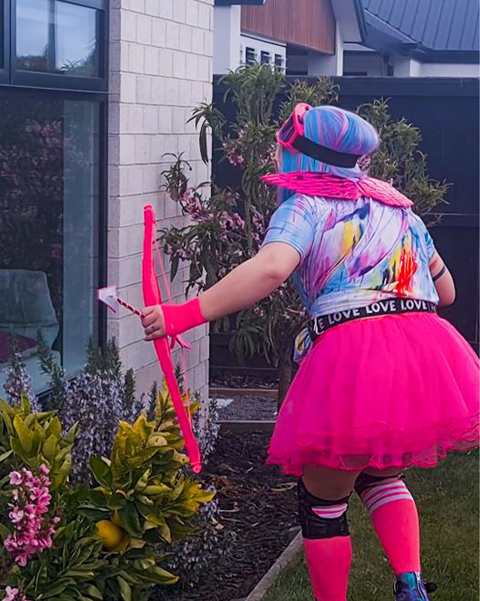 Altitude Pole's Cupid character standing outside of a lounge window peeking in.