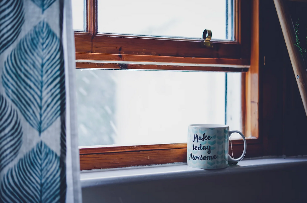 Mug on a windowsill with rain outside window