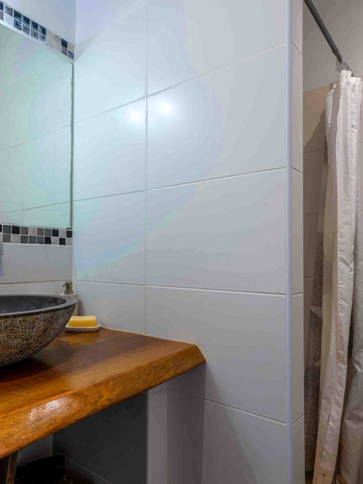 Salle de bain moderne avec vasque en pierre et douche.