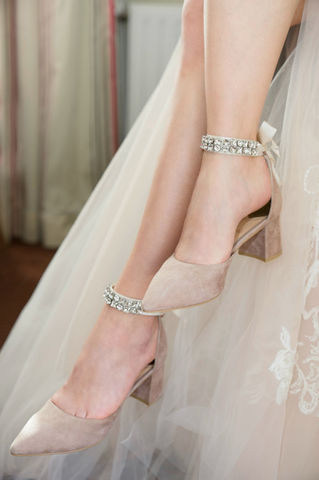 Brautschuhe mit Kristallen: Elegante, beige Pumps mit Blockabsatz und funkelnden Anhängern.