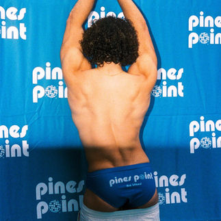 Guest posing in front of a Pines Point backdrop in Fire Island Pines.