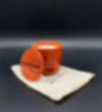 Large orange concrete mojave fruit scented candle side view with its lid standing upright brandishing Creatcrete logo