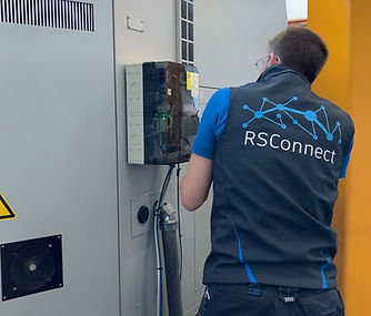 Abgebildet wird ein RSConnect Mitarbeiter beim Einbau einer Lösung zur Maschinendatenerfassung außerhalb des Schaltschranks.