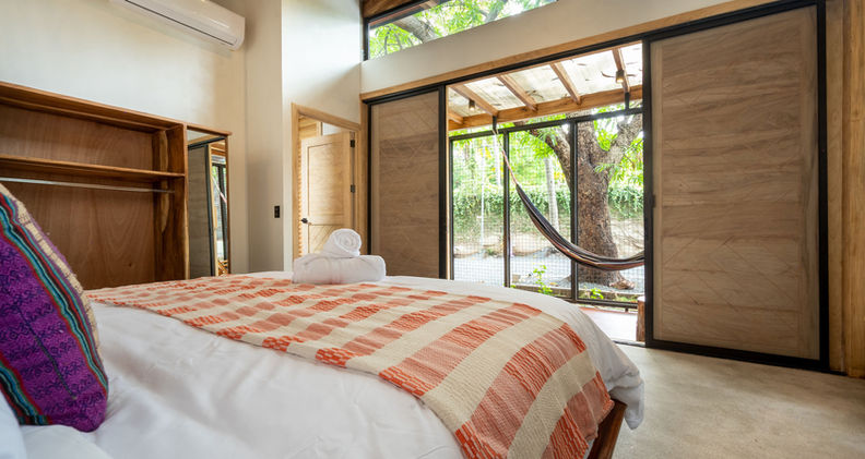 11 - Bamboo Suite - Bed to porch with hammock.jpg
