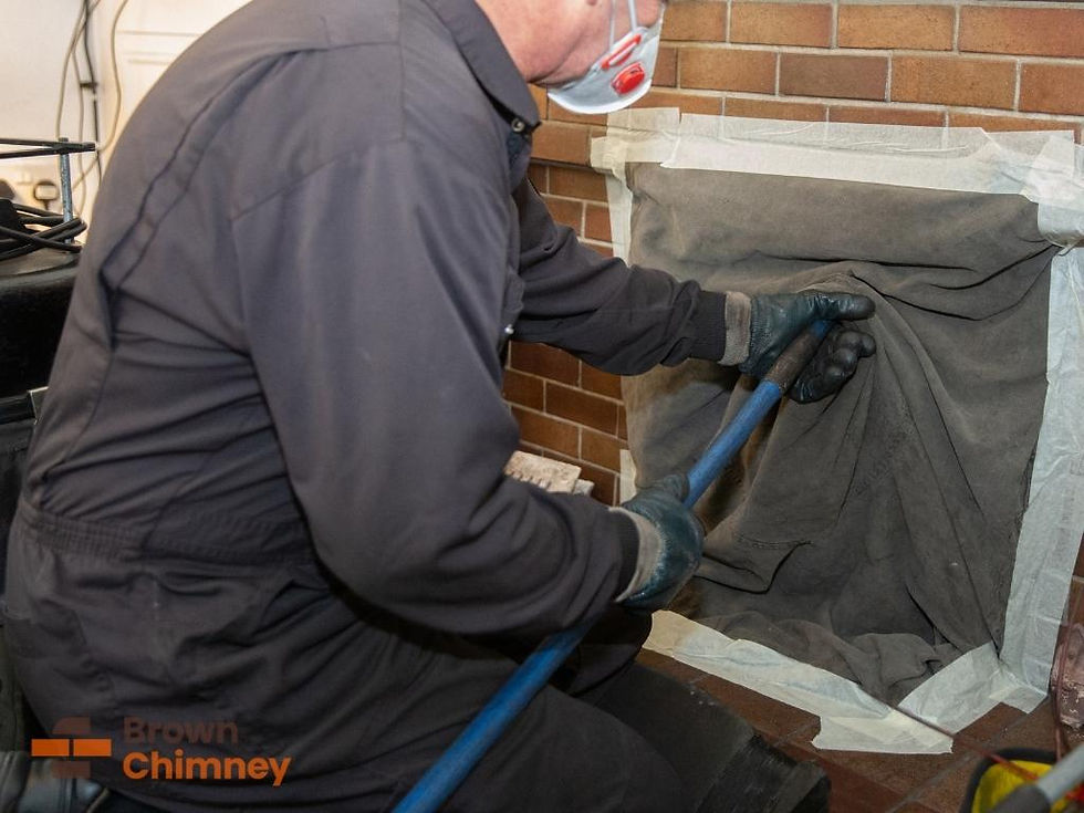 Worker in a mask and gloves cleaning a chimney with a brush. Brick background, tools nearby. "Brown Chimney" logo at bottom left.