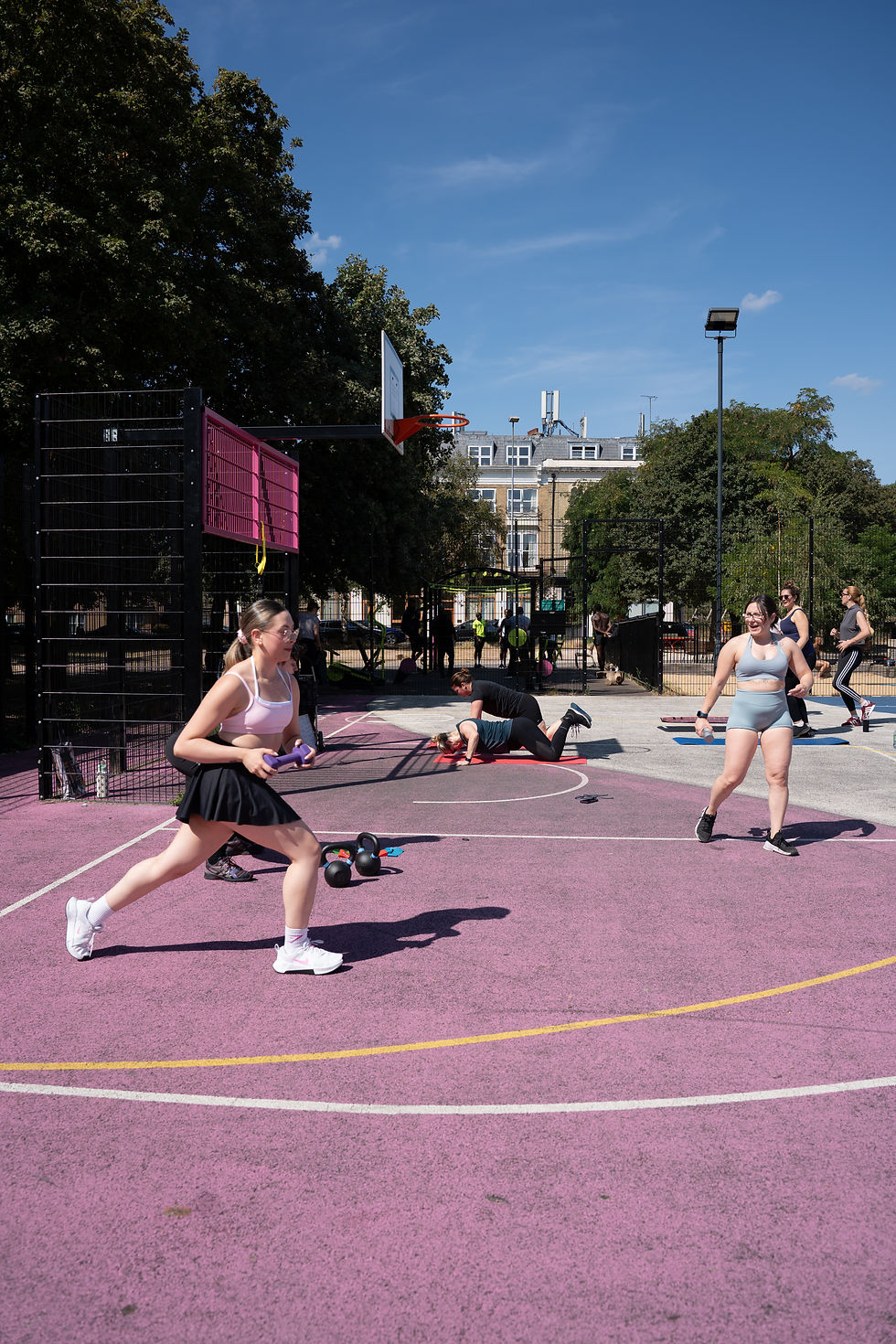 Women playing tennis on an outdoor urban court in a park