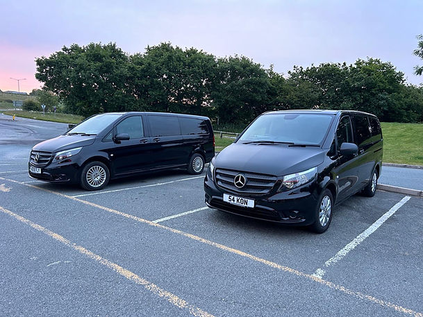 Two black Mercedes minibus taxis parked outdoors