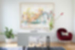 colorful framed art in a home office with a burgundy velvet chair