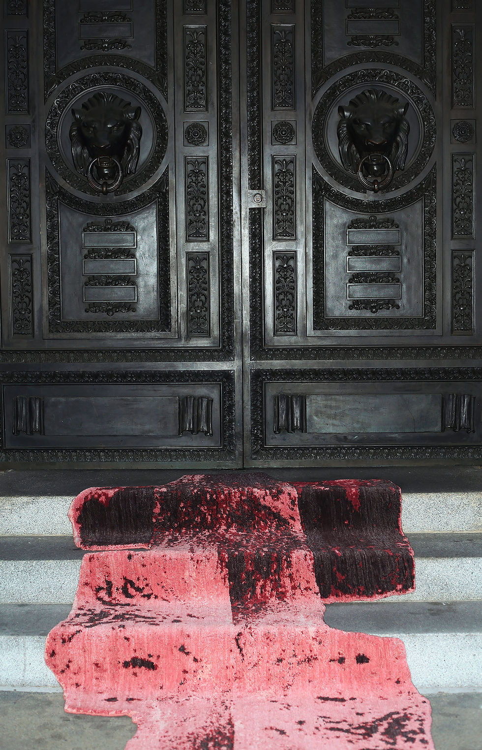 red and pink modern low-pile rug in front of black french doors