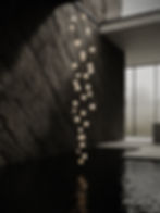 floor to ceiling hanging light against black slate wall