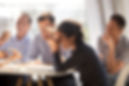 Indian woman laughing at funny joke eating pizza with diverse coworkers in office, friendl