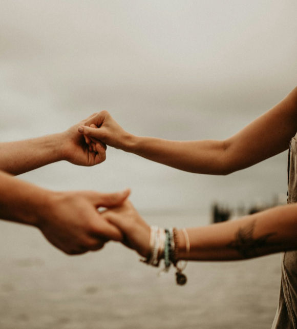 Deux mains qui se touchent symbolisant l'accompagnement naturopathique bienveillant pour sortir des kilos émotionnels