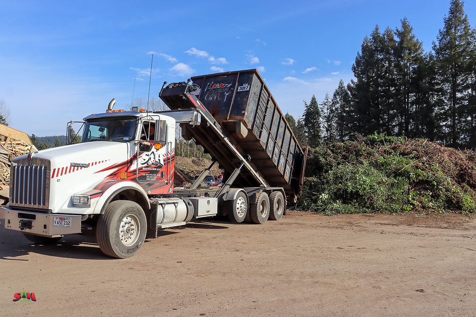 S&H Dump truck unloading a drop box of yard debris