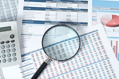 financial documents with magnifying glass over them.jpg