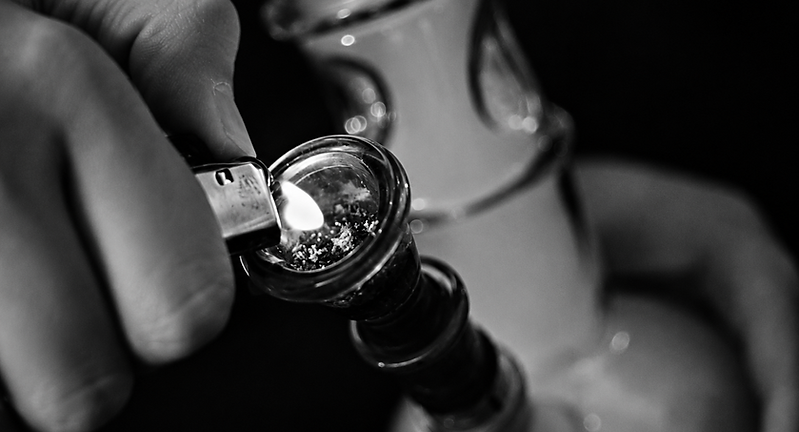 Person lighting a bong with a lighter