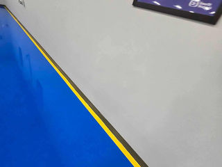 Bright blue industrial walkway with yellow lines providing clear path guidance.