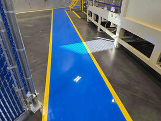 High-contrast blue and yellow epoxy safety path providing clear direction in a large facility.