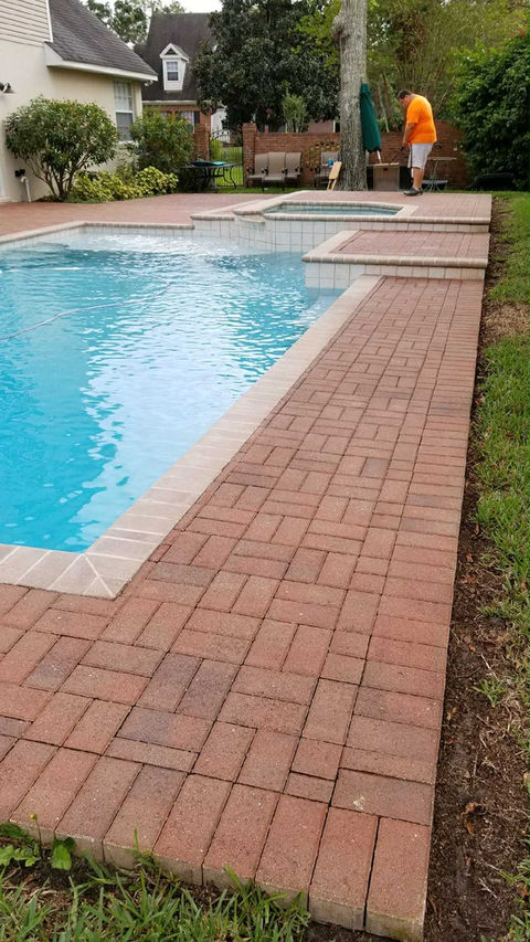 Paver Sealing Pool Deck in Central Florida with worker in orange shirt in the background