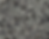 Close-up of a surface with a speckled pattern of gray, black, and white flakes. The texture is random and abstract, creating a mosaic effect.