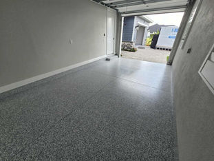 Smokey Blue Color Chip Blend on smaller garage Floor. Mixture of grey and blues. The topcoat reflect the sun a bit as well. Storage container is in the background