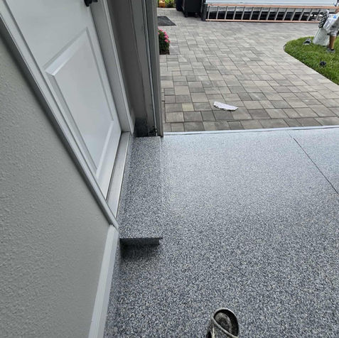 Detailed image of Domino epoxy flooring, highlighting the consistent distribution of polymer flakes in neutral tones for a clean and durable surface.