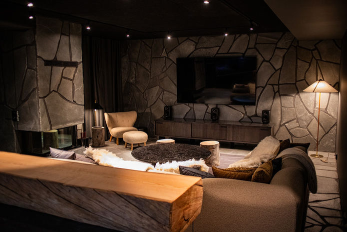 kellarin oleskelutila, jossa sohva ja takka