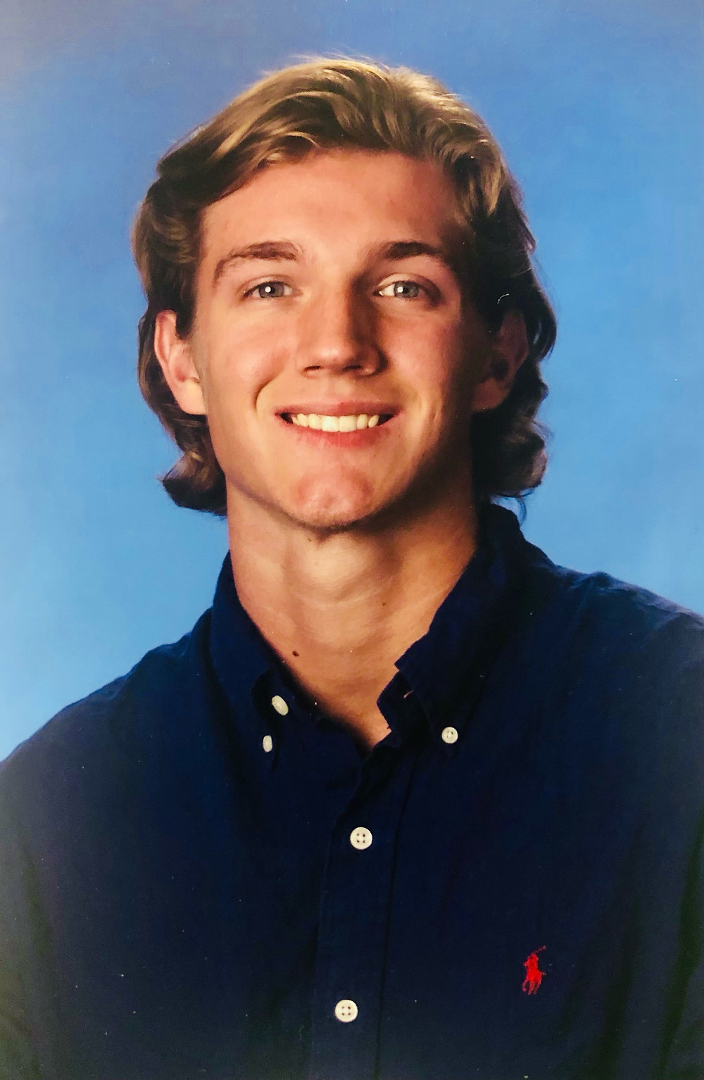Headshot of Michael, male, with a blue background.