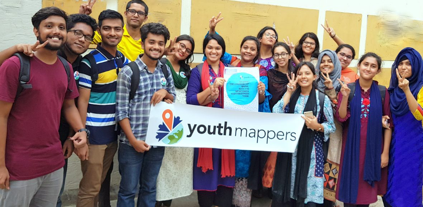 Group of happy students(male and female) holding YouthMappers sign making peace signs.