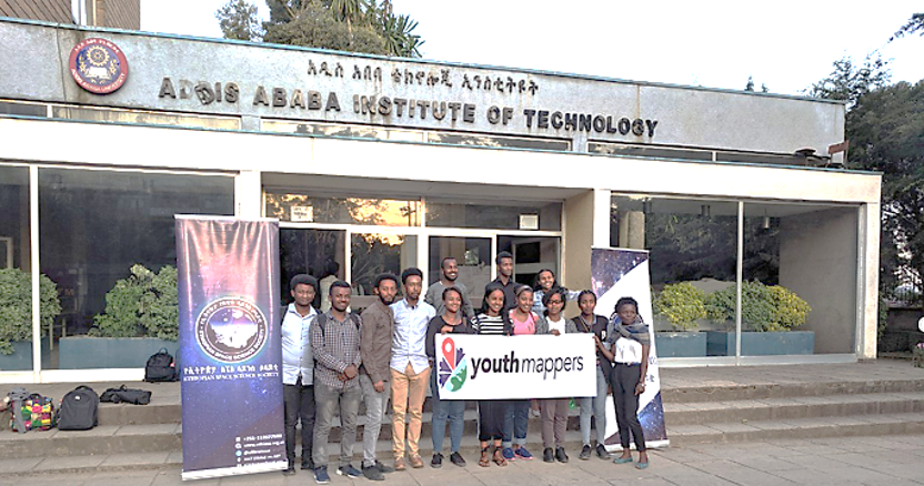 Group of students in front of building titled "Addis Ababa Institute of Technology" holding a YouthMappers banner.