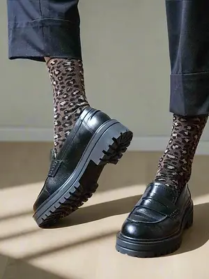 Leo-Socken von Klue, die mit schwarzen Schuhen präsentiert werden.