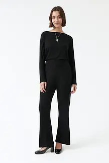 Person mit einem fair produzierten schwarzen Outfit von amt. studio, die in die Kamera schaut. 