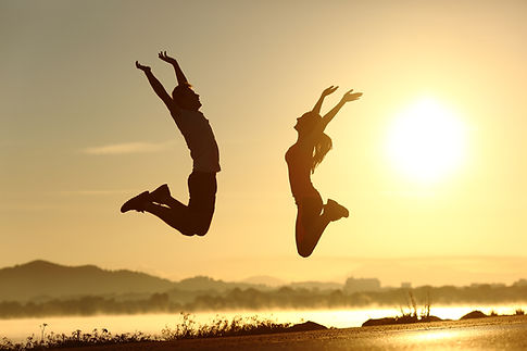 shutterstock_246061795Fitness couple jumping happy at sunset with the sun in the backgroun