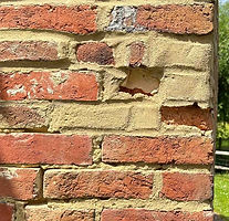 Old repair of spalled bricks on listed property using cement