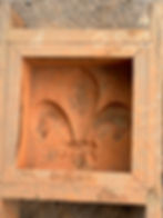 A fleur-de-lys wooden brick form