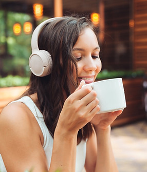 young-beautiful-woman-with-headphones-is-sitting-table-summer-cafe-drinking-coffee-tea-gen