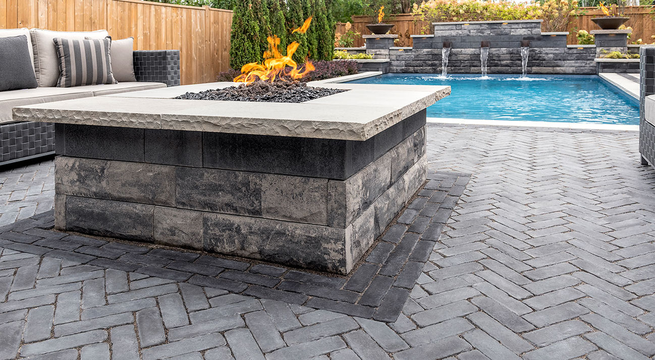 a fire pit in a backyard next to a pool