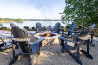 a group of chairs around a fire pit overlooking a lake