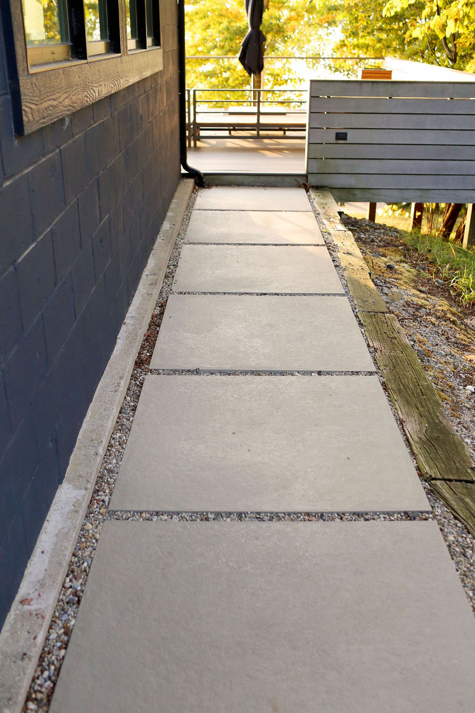 a concrete walkway with gravel on the side of it