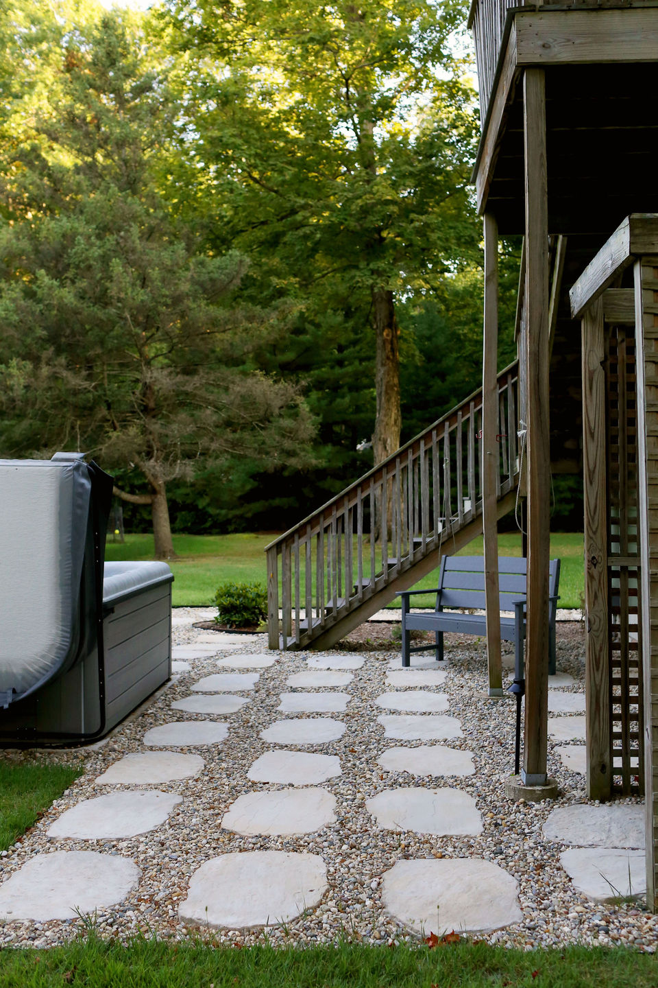 a hot tub sits on a patio next to stairs