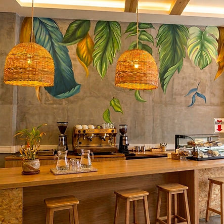 Mural de hojas gigantes de Roxana Tejada en una cafetería de Barcelona