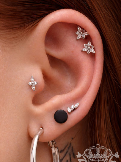 Zwei Ohrknorpelpiercings mit Kristallsteine auch Helixpiercing genannt sowie ein Traguspiercing mit Kristallsteinen