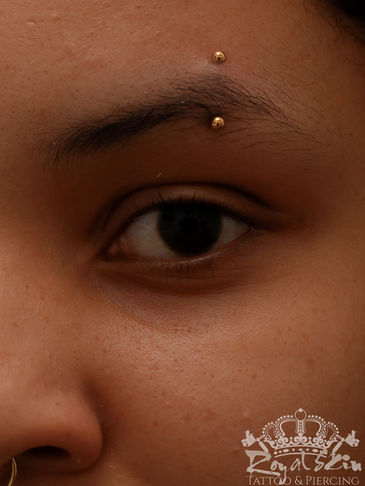 Gepiercte Augenbraue mit einem Goldstecker.