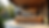 Eye-level view of outdoor kitchen with stone countertops and wooden cabinets