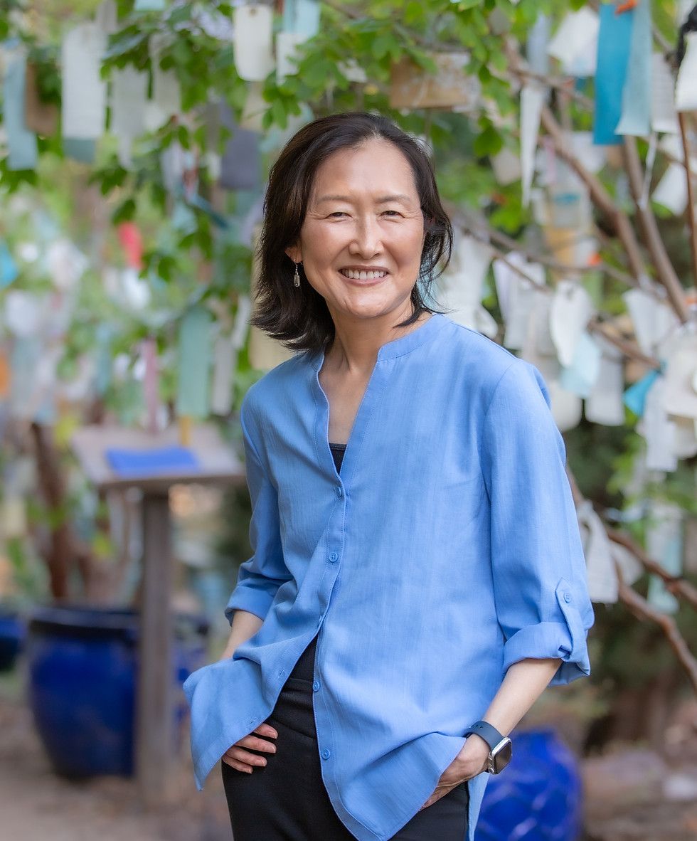 Portrait of life coach, Shannon, in a blue shirt in a nature environment