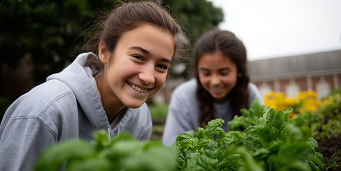 Two smiling girls tending plants