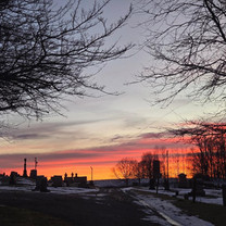 Cemetery silhouettes against a vibrant sunset sky.
