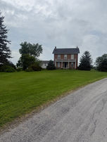 Brick farmhouse on a grassy lawn