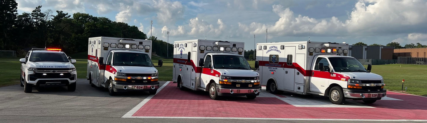 Four ambulances and a pickup truck parked on a helipad